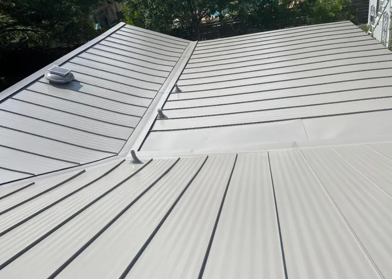 Solar attic fan installed on a metal roof for Roof Ventilation in Iola